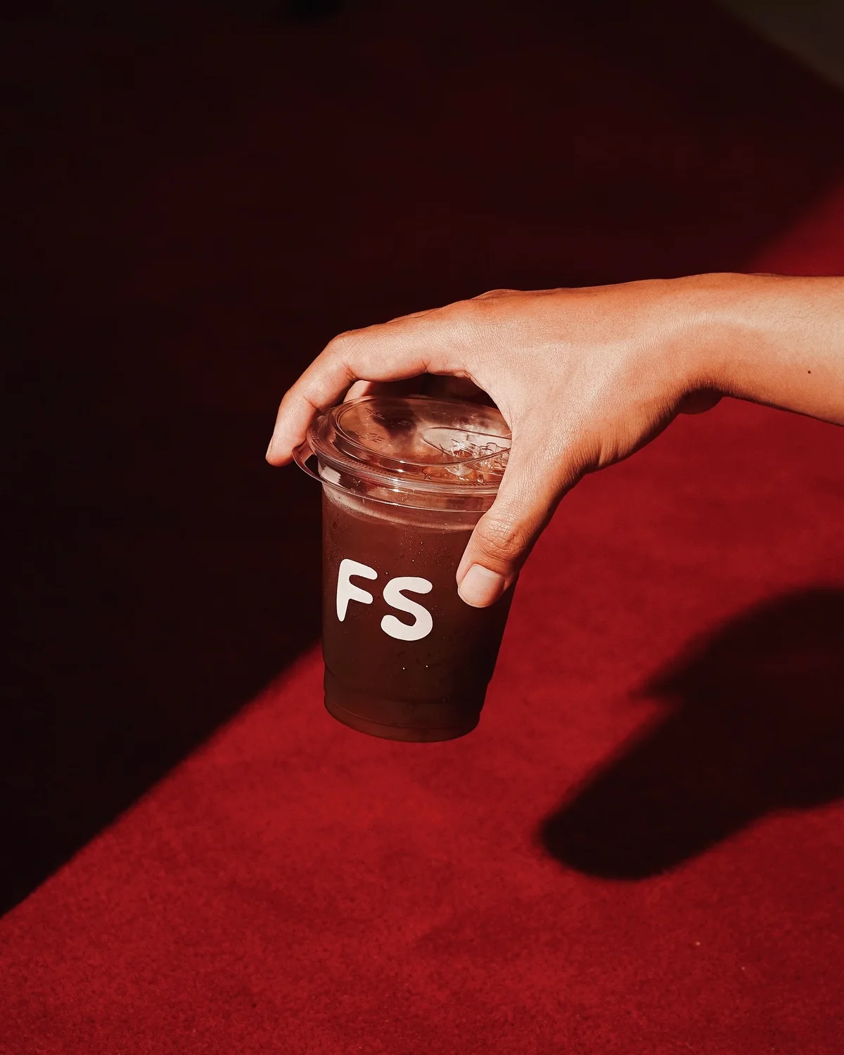 Hand holding a FourSense takeaway coffee cup