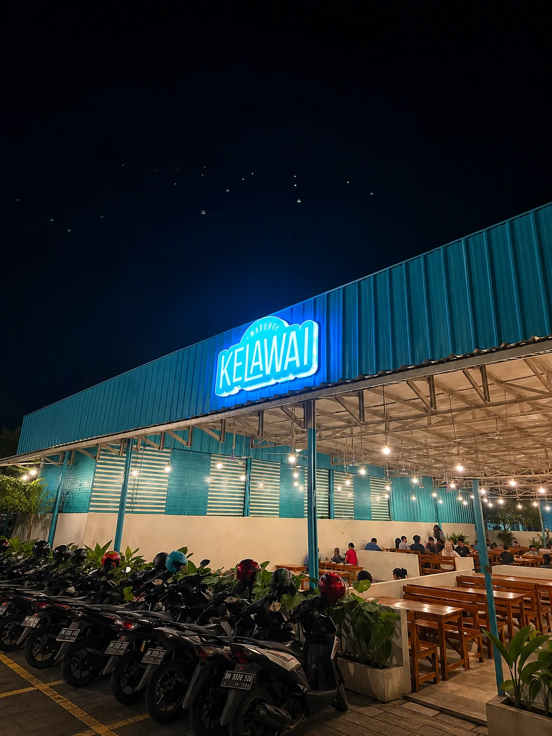 Warkop Kelawai storefront and seating at night